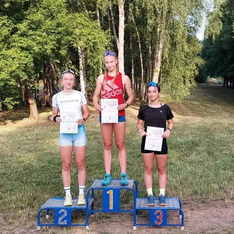 Junge Sportlerinnen bei einer Siegerehrung am Waldrand